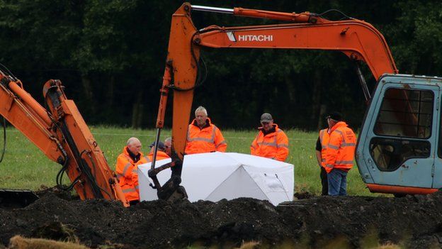 Members of the Independent Commission for the Location of Victims' Remains work at the scene