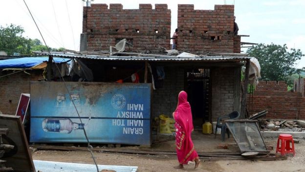 A woman walks past a closed down alcohol shop close to the Bihar border