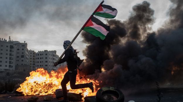 Un manifestante palestino porta una bandera palestina.