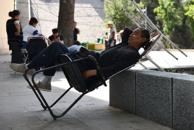 Un hombre chino se echa la siesta en un parque