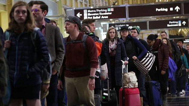 Pasajeros hacen fila en un aeropuerto.