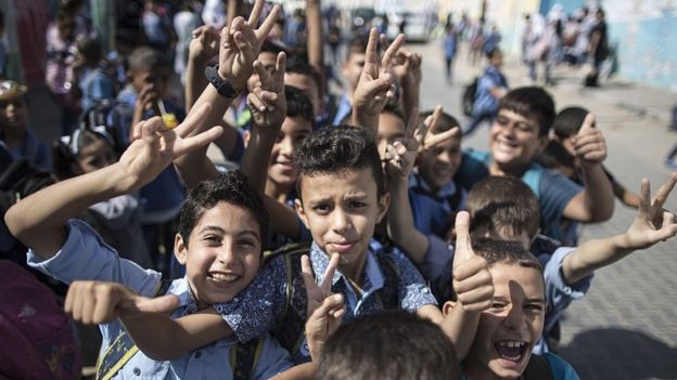 Niños de escuela saludando a la cámara