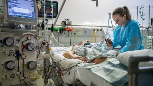 Médica e paciente em cama de hospital