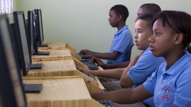 Niños trabajando con computadoras.