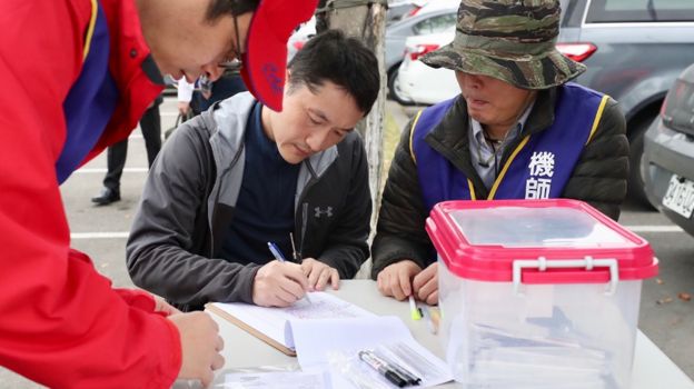 台北(松山)机场外华航机师向工会干部交出“检定证”加入罢工(台湾中央社图片8/2/2019)