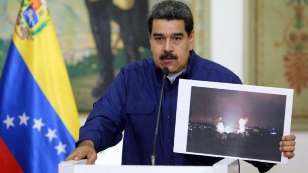 Handout picture released by the Venezuelan presidency showing Venezuelan President Nicolas Maduro showing a picture of the fire at a state-owned electricity company Carpooled power substation, during a press conference at the Miraflores Presidential Palace in Caracas, Venezuela on March 11, 2019