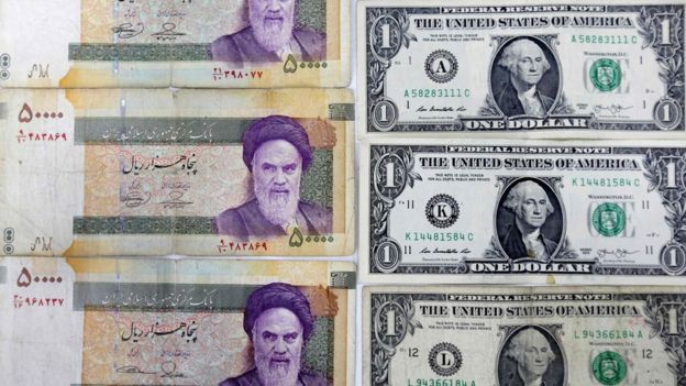 Close-up image of Iranian Rial banknotes and US one dollar bills