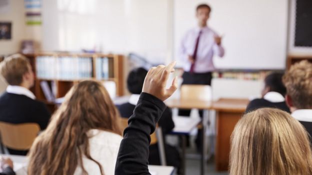 Aluno levanta a mão em sala de aula