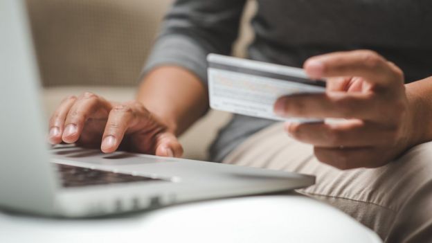 hombre pagando con tarjeta en una computadora