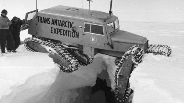 Vehículo con orugas balanceándose sobre una grieta en el hielo