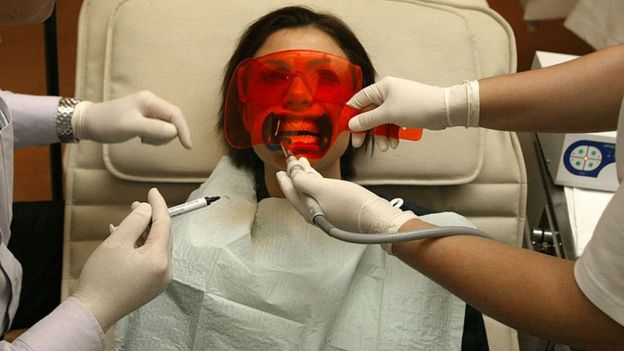 Mujer que tiene procedimiento de blanqueamiento dental