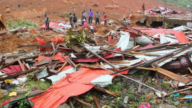 People inspect the damage after a mudslide in the mountain town of Regent, Sierra Leone August 14, 2017