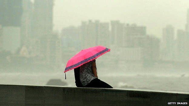 A couple huddle together under an umbrella in Mumbai