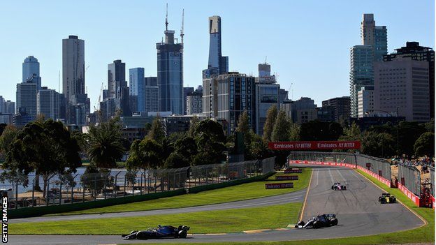 Cars go round the track in Melbourne in bright sunshine