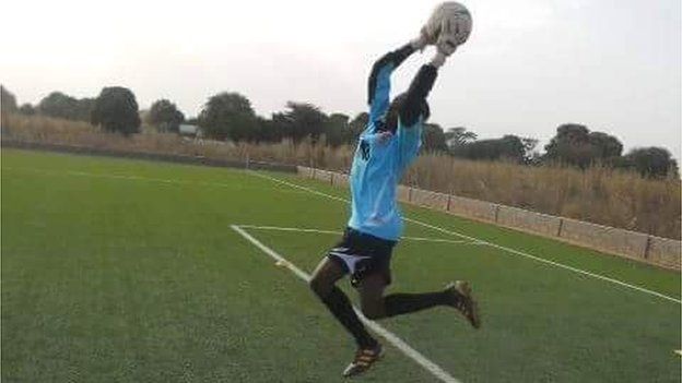 Fatim Jawara throws a ball on a football pitch.