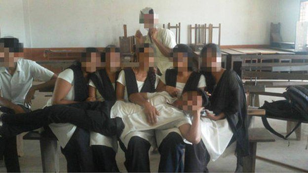 A schoolboy lying across a five female classmates