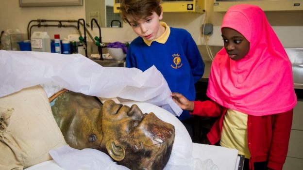 Enfants examinant une tête de Frankenstein