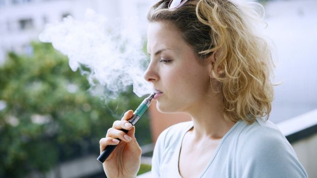 Mujer fumando un cigarrillo electrónico.