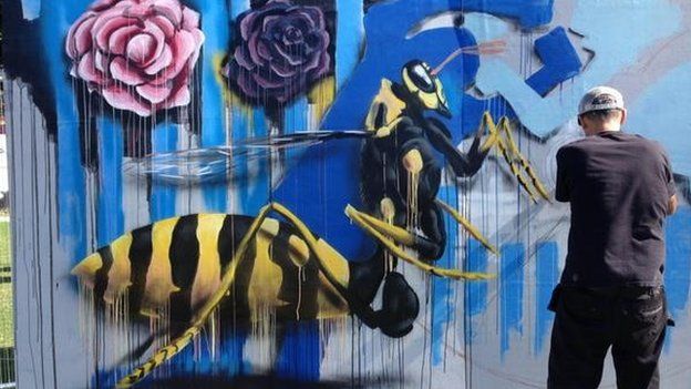 Des X paints some giant wasps on hoardings in South Street Park