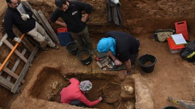 Voluntarios trabajan en una fosa común.