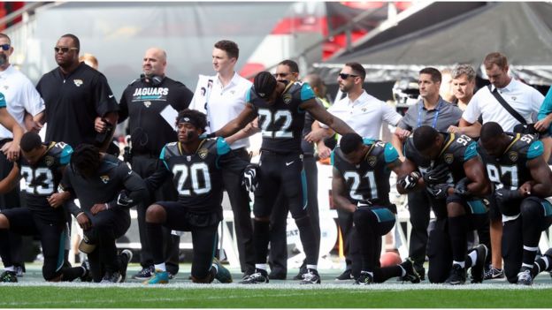 Члены команды Jacksonville Jaguars преклоняют колена в знак протеста во время исполнения американского гимна на стадионе Уэмбли в Лондоне