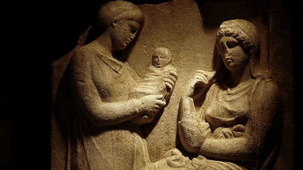 Representación en un obelisco griego del siglo IV a.C. de dos mujeres y un bebé