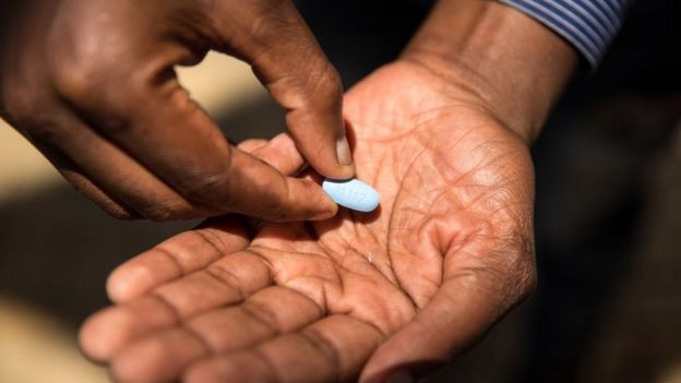 Homem segura pílula para HIV
