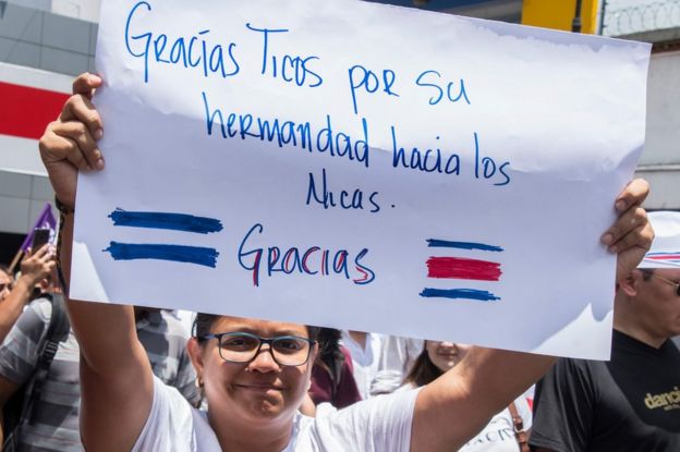 Nicaragüense mostrando una pancarta en la marcha de Costa Rica.
