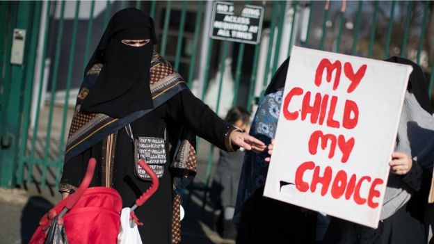 Женщина в чадре и плакат "Мой ребенок - мой выбор".