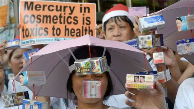 Manifestantes realizan una manifestación frente a una farmacia en Manila, mostrando productos supuestamente adulterados con mercurio