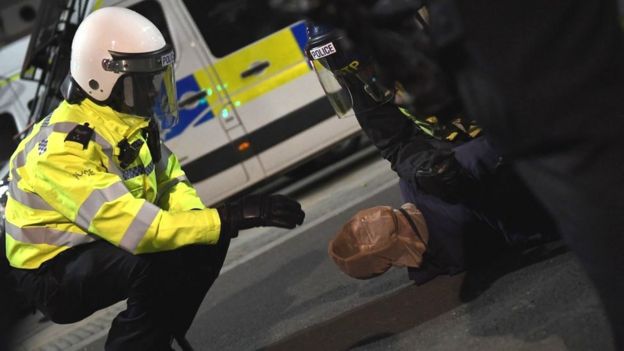 A protester is placed in a spit hood as he is restrained by police during a Black Lives Matter protest in London in June 2020