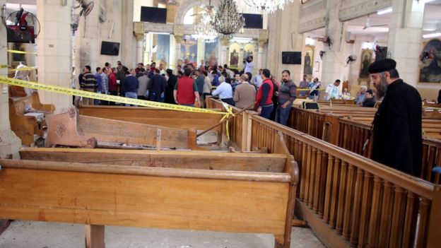 A coptic priest looks on at the damages as security personnel investigate the scene of a bomb explosion inside Mar Girgis church in Tanta, 90km north of Cairo, Egyp