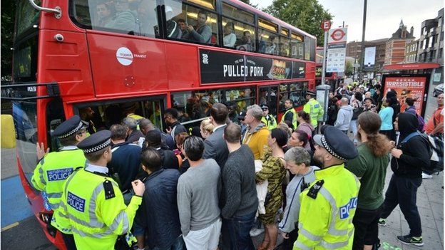People try to board a bus in Stratford