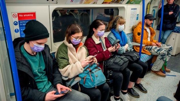 Gente con mascarillas en el metro de Londres.