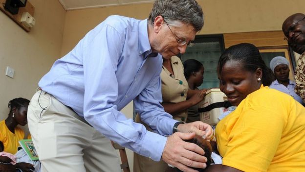 Bill Gates acaricia a un niño en los brazos de su madre en áfrica