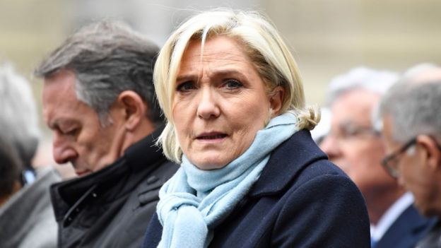 Marine Le Pen (French presidential election candidate for the far-right Front National (FN) party, Marine Le Pen (C) and French Junior Sports Minister, Thierry Braillard (L) attend a ceremony honouring the policeman killed by a jihadist in an attack on the Champs Elysees, on April 25, 2017 at the Paris prefecture building.