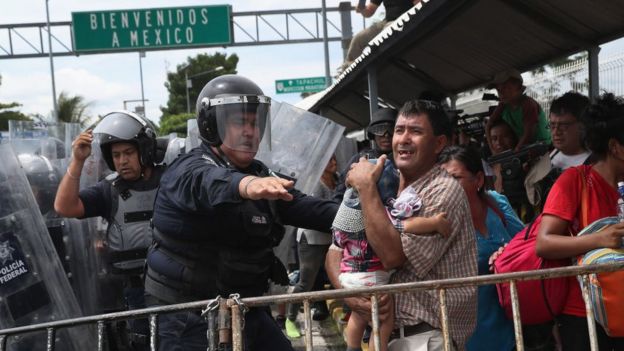 Policial contém imigrantes na fronteira entre México e Guatemala