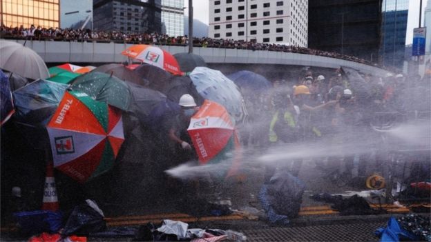 Протетсующие защищаются с помощью зонтиков