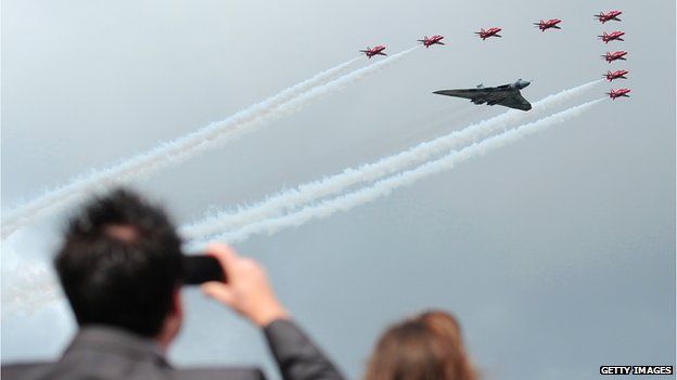 Spectator takes a picture of the Red Arrows and Avro Vulcan