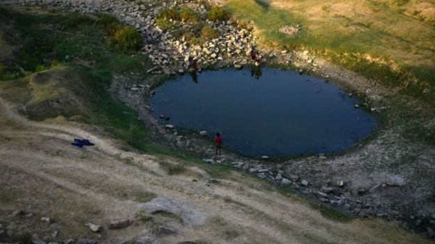 Indian villagers try to catch fish in a pool of the shrunken Mansaita River near Allahabad on May 4, 2016.