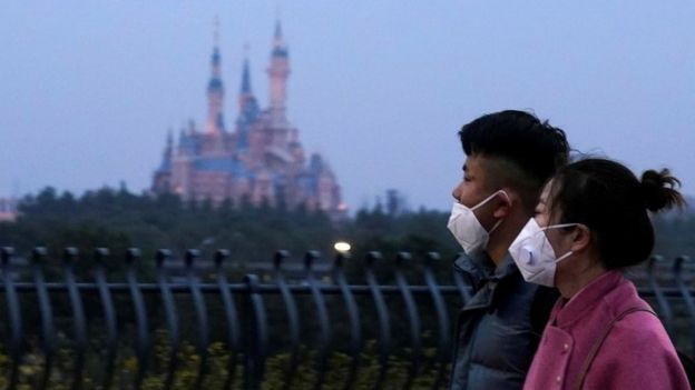 People walk past Shanghai Disney resort - 24 January