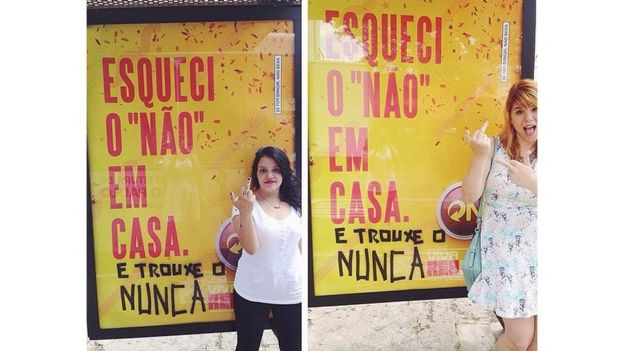 Ativistas posam em frente a cartaz