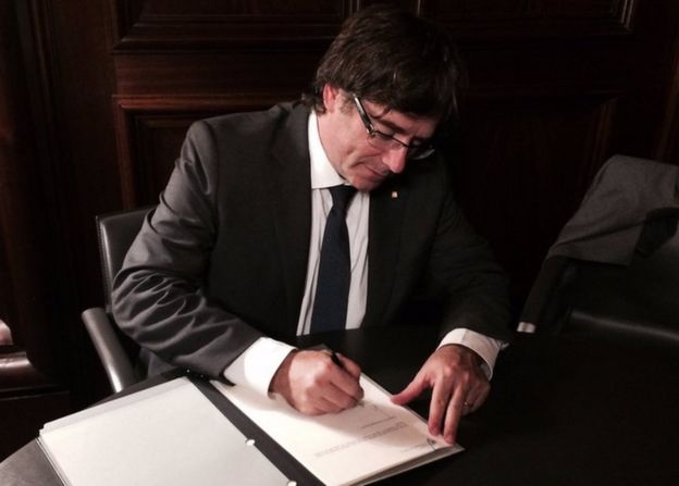 Presidente catalão Carles Puigdemont assinando lei que prevê a consulta popular