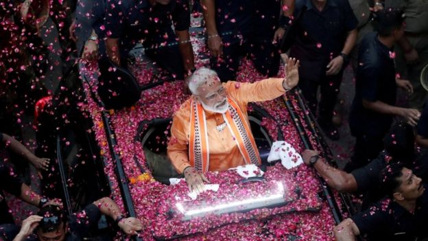 Prime Minister Narendra Modi waves at supporters during a road show in Varanasi.