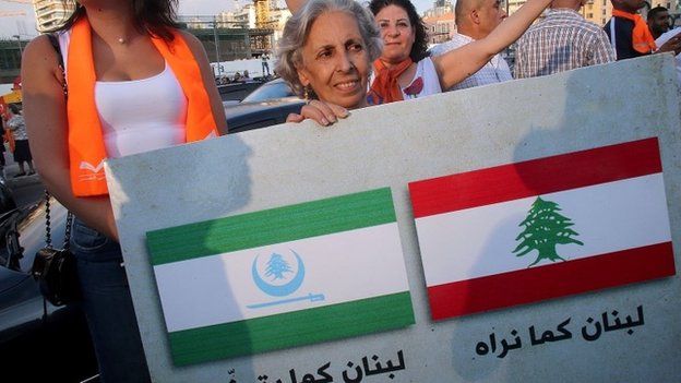 Supporters of Lebanese Christian leader Michel Aoun's opposition Free Patriotic Movement (FPM) hold a placard reading in Arabic "Lebanon as we see it" (R) and "Lebanon how they wish it to be"