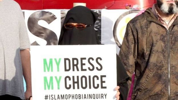 امرأة مرتدية البرقع تتظاهر بالقرب من مقر جونسون الانتخابي