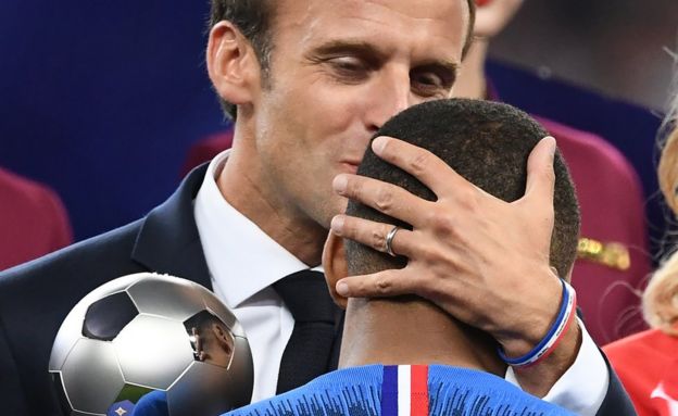Macron besando a Mbappé.