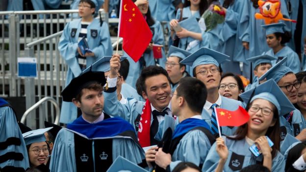 Students wave Chinese flags at Columbia University's commencement ceremony in May 2019.