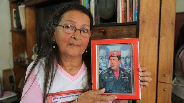 Teresa holds up a painting of President Chávez