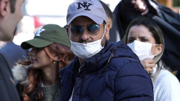 Visitors to New York City's theatre district wear face masks as a precaution